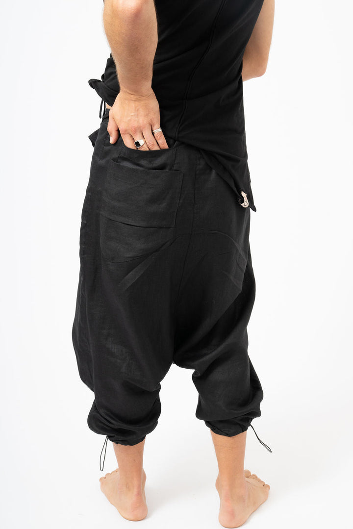 Person wearing black baggy pants on a white background