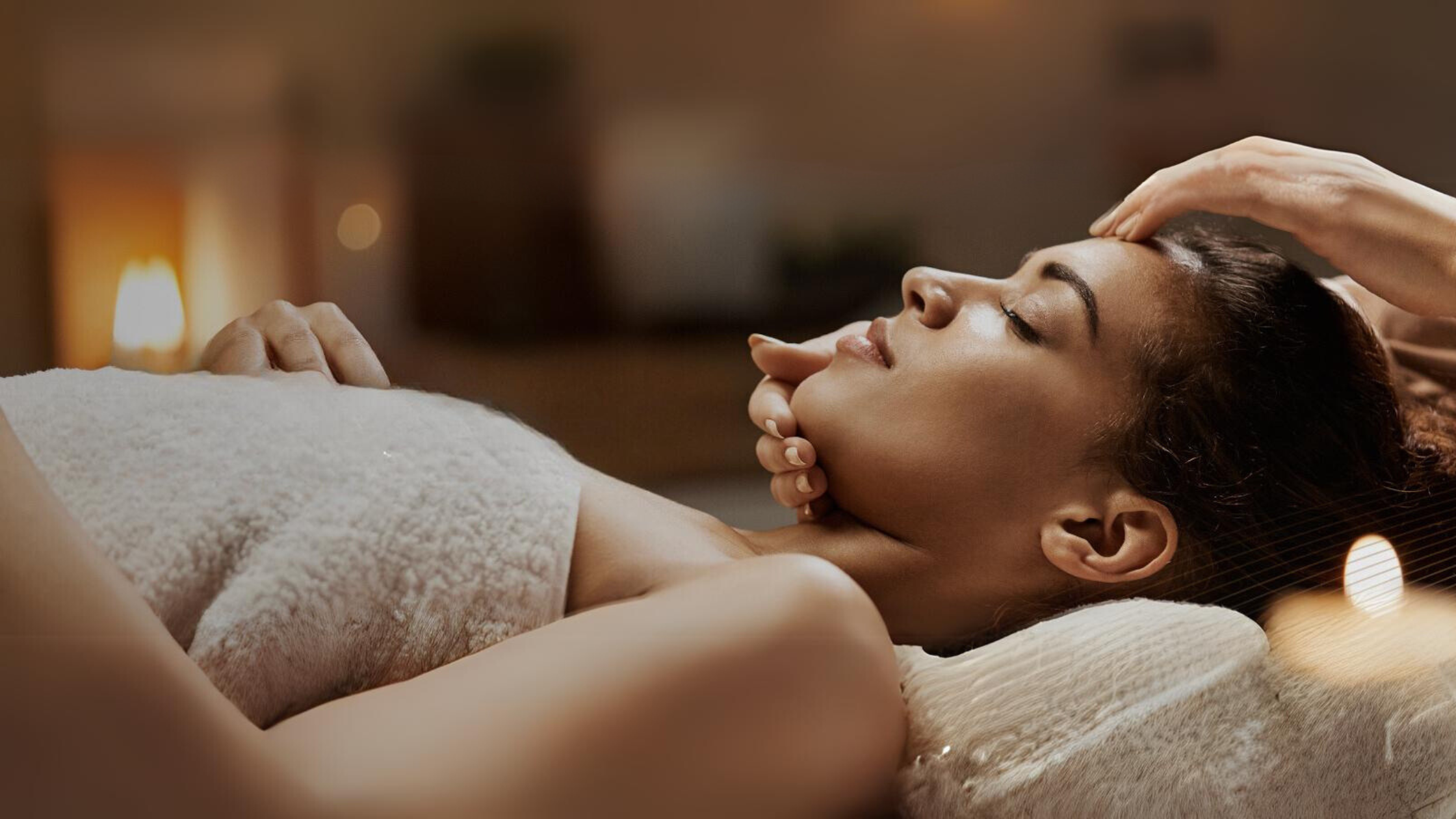 Relaxing spa scene with a woman receiving a facial massage, enveloped in a serene, warmly lit ambiance